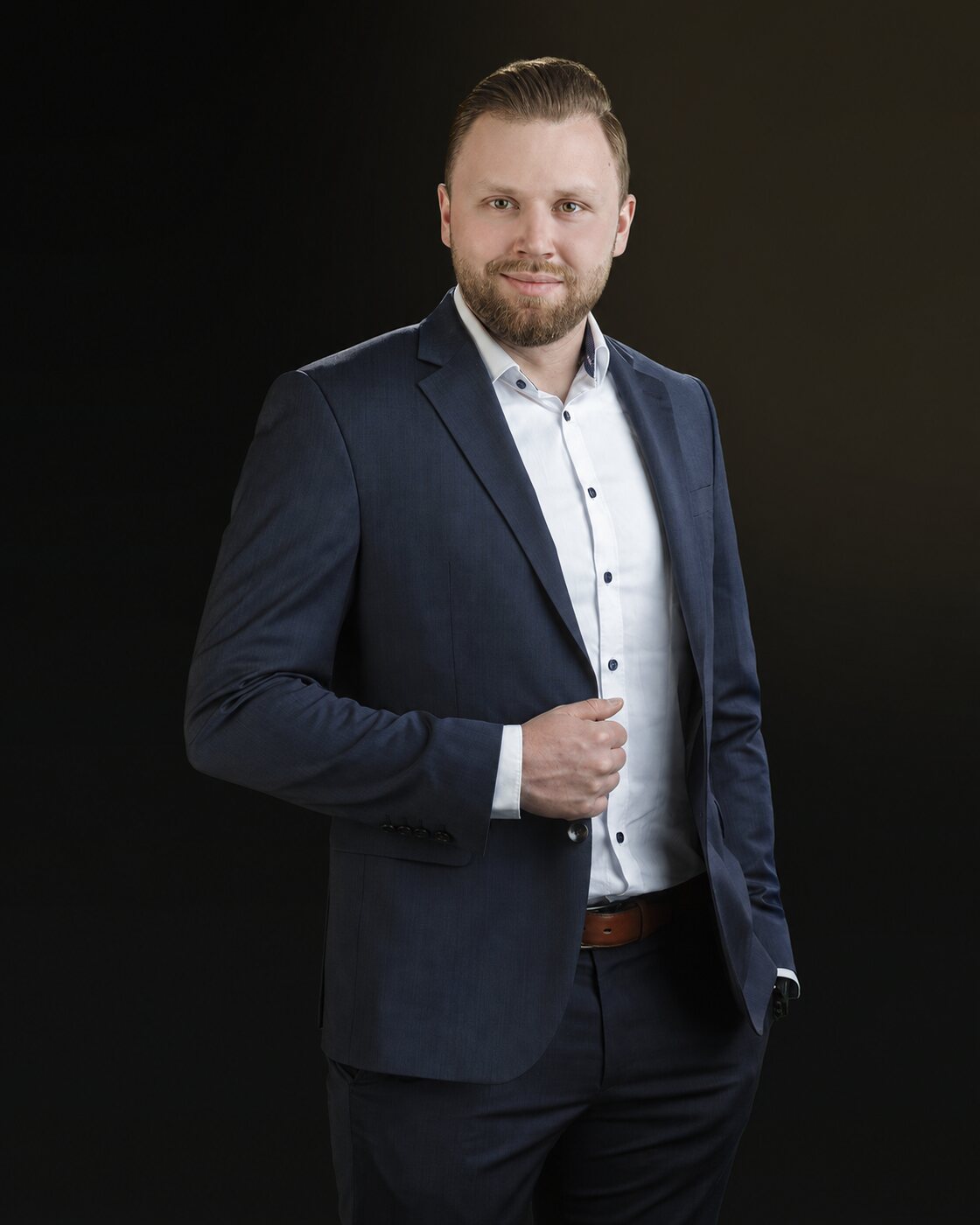 Dennis Wodzikowski im dunklen Anzug, Porträtaufnahme.